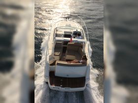 A couple enjoys a sunny day aboard a sleek yacht, cruising through shimmering waters — perfect for a relaxing getaway on the sea.