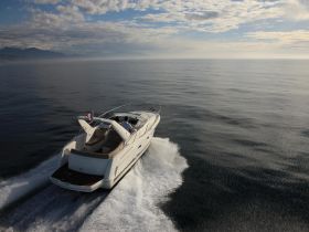 A couple enjoys a serene ride on a yacht, gliding through calm waters under a picturesque sky — perfect for romantic getaways or leisurely cruises.