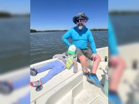 A father and his child enjoy a relaxing moment on a boat, showcasing a perfect family outing on the water.