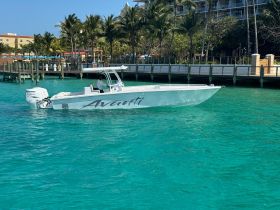 A sleek speedboat named 'Avanti' glides through crystal-clear turquoise waters, showcasing its elegant design and perfect for thrilling water adventures.