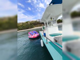 A boat is anchored near a colorful inflatable tube, ready for a fun day of tubing on the water. The vibrant scenery and equipment set the stage for exciting water activities.