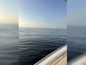 A serene view from the deck of a boat, showcasing calm waters and a clear sky — perfect for a peaceful day on the water.