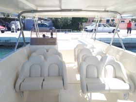 Interior view of a boat showcasing comfortable seating and helm area, perfect for a day out on the water.