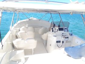 The interior of a sleek boat featuring a well-equipped helm and comfortable seating, perfect for a day out on the water.