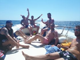A lively group of friends enjoys a fun day on the boat, celebrating under the sun with laughter and good vibes on the open water.