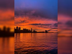 A breathtaking sunset over Sydney Harbor, showcasing the iconic Sydney Opera House and Harbour Bridge, perfect for capturing the beauty of the city.
