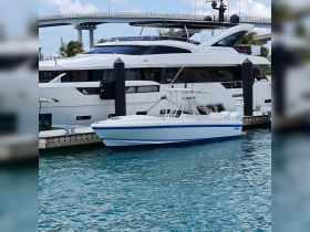 A sleek speedboat docked alongside a luxurious yacht, showcasing the beauty of marine vessels in a vibrant marina setting.