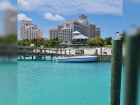 A sleek speedboat is docked in clear turquoise waters, with a luxurious resort in the background, perfect for a day of relaxation and adventure.