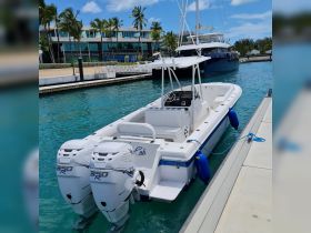 A sleek speedboat docked in clear turquoise waters, showcasing its powerful twin engines and inviting design — perfect for thrilling water adventures.