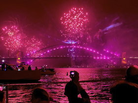 A vibrant display of fireworks lights up the Sydney Harbour, with guests enjoying the spectacular view from their boats — a perfect celebration atmosphere.