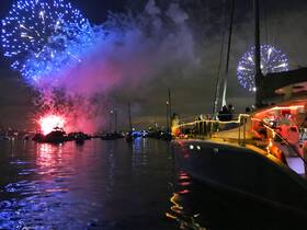 A stunning display of fireworks lights up the night sky as guests celebrate aboard a beautifully decorated boat, creating a perfect backdrop for memorable moments on the water.