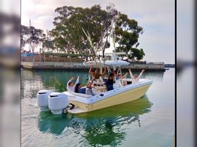 A lively group celebrates aboard a fishing boat, showcasing the joy of a day on the water with friends. Perfect for fishing trips or group outings.