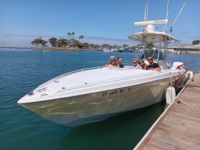 A cheerful group of friends poses on a boat at the dock, ready for a day of fun on the water — perfect for gatherings and celebrations.