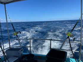 View from the helm of a fishing boat, showcasing fishing gear and the open sea — perfect for fishing enthusiasts looking for adventure on the water.