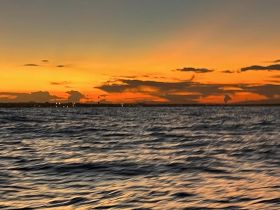 A blurry image capturing a sunset over the water, creating a serene yet indistinct atmosphere.