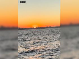 A stunning sunset over the water, capturing the serene beauty of the coastline — perfect for evening boat cruises.