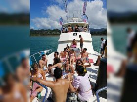 A lively group enjoys a fun day on a boat, soaking up the sun and celebrating together — perfect for social gatherings and party cruises.