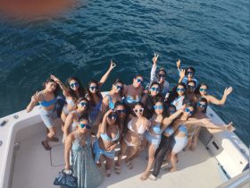 A vibrant group of friends celebrates together on a boat, showcasing fun and camaraderie under the sun — perfect for a memorable day on the water.