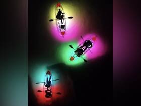 A vibrant night kayaking experience with illuminated kayaks, showcasing a group enjoying the water under colorful lights — perfect for adventurous outings.