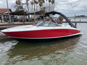 A striking side view of a Regal speedboat docked, showcasing its sleek design and vibrant red color, perfect for water adventures.