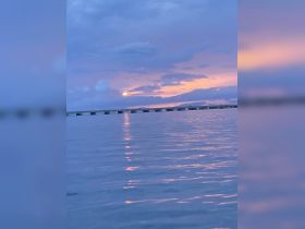 A serene sunset view over calm waters, showcasing the beautiful reflections and tranquil atmosphere, perfect for evening boat cruises.