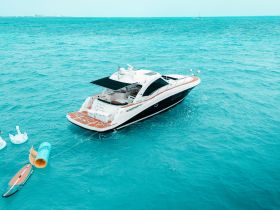 A stunning aerial view of a luxurious yacht cruising through vibrant turquoise waters, perfect for upscale boating adventures.