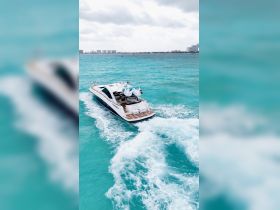 An aerial view of a sleek yacht cruising through vibrant turquoise waters, showcasing its elegant design and perfect for luxury outings.