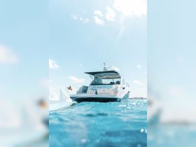 A stunning view of the 'Sea Seren' yacht anchored in crystal-clear waters, showcasing its sleek design against a bright blue sky.