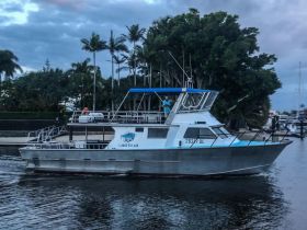 A sleek boat navigates through calm waters, showcasing its structure and design, perfect for fishing or leisure trips. Contact for bookings at 0403 531 428.
