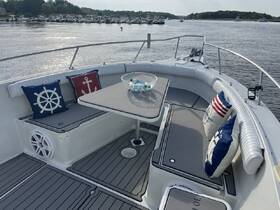 A cozy seating area inside a boat, featuring nautical-themed cushions and a table, perfect for relaxing while enjoying views of the water.