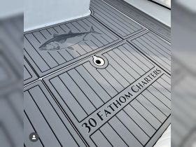 Detailed view of the deck featuring the logo of '30 Fathom Charters' along with a fish illustration, showcasing the boat's fishing focus.
