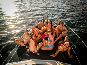 A lively group of friends enjoys a sunny day on the boat, capturing the essence of summer fun and camaraderie on the water.