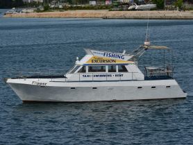 The 'Flipper' boat is docked, showcasing its structure and signage for fishing excursions and rentals, perfect for family adventures on the water.