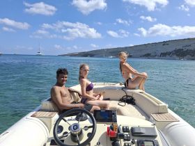 A group of friends enjoys a sunny day on a boat, capturing the essence of summer fun and relaxation on the water.