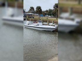 A sleek speedboat docked at the marina, showcasing its streamlined design and fishing gear, perfect for water adventures.