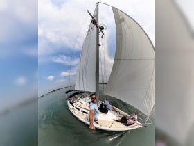 A group of friends enjoys a day of sailing, capturing smiles and camaraderie aboard a beautiful sailboat. Perfect for memorable outings on the water.