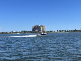 A speedboat glides through the water, showcasing a lively day on the water with friends and family enjoying the ride.