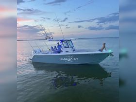 A serene sunset view of a fishing boat with a child relaxing on the bow, showcasing a perfect family outing on the water.