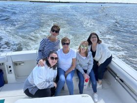 A cheerful group of friends enjoys a day out on the boat, capturing memories and celebrating together on the water.