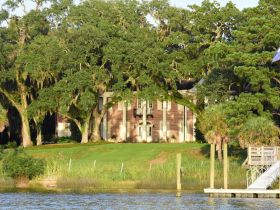 A scenic view of a large house surrounded by lush greenery, showcasing the natural beauty of the area.