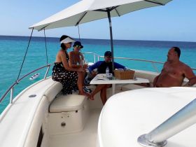 A group of friends enjoys a relaxing moment on a boat, sipping cocktails and taking in the stunning ocean views — perfect for a day of celebration on the water.