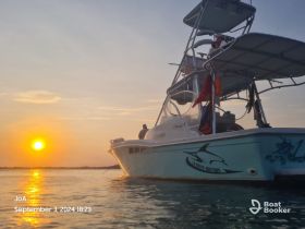 A stunning sunset view with a boat silhouetted against the vibrant sky, capturing the essence of a perfect evening on the water.