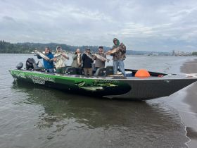 A group of anglers proudly displays their catch while aboard a fishing boat, celebrating a successful day on the water in the Columbia River.