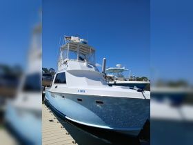 A stunning view of a yacht docked at the marina, showcasing its sleek design and vibrant blue accents against a clear sky.