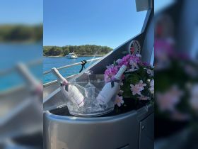 A stylish display of chilled champagne and flowers on a boat, perfect for celebrating special occasions while enjoying the beautiful surroundings.