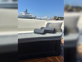 A stylish seating area on a yacht featuring neatly arranged towels, perfect for lounging and enjoying the sun on the water.