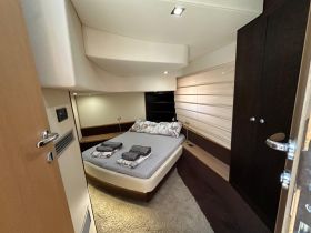 A cozy cabin interior of a boat featuring a comfortable bed and modern furnishings, perfect for relaxing during a sailing trip.