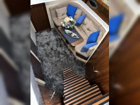 A cozy interior view of a boat's lounge area featuring comfortable seating and decorative elements, ideal for relaxation while on the water.