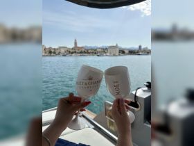 Two guests toast with Moët & Chandon champagne while enjoying a scenic view from their boat, perfect for celebrations and special occasions on the water.
