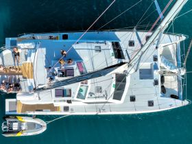 A vibrant aerial view of a catamaran filled with guests enjoying their time on the water, showcasing the perfect setting for group celebrations and fun on a sunny day.